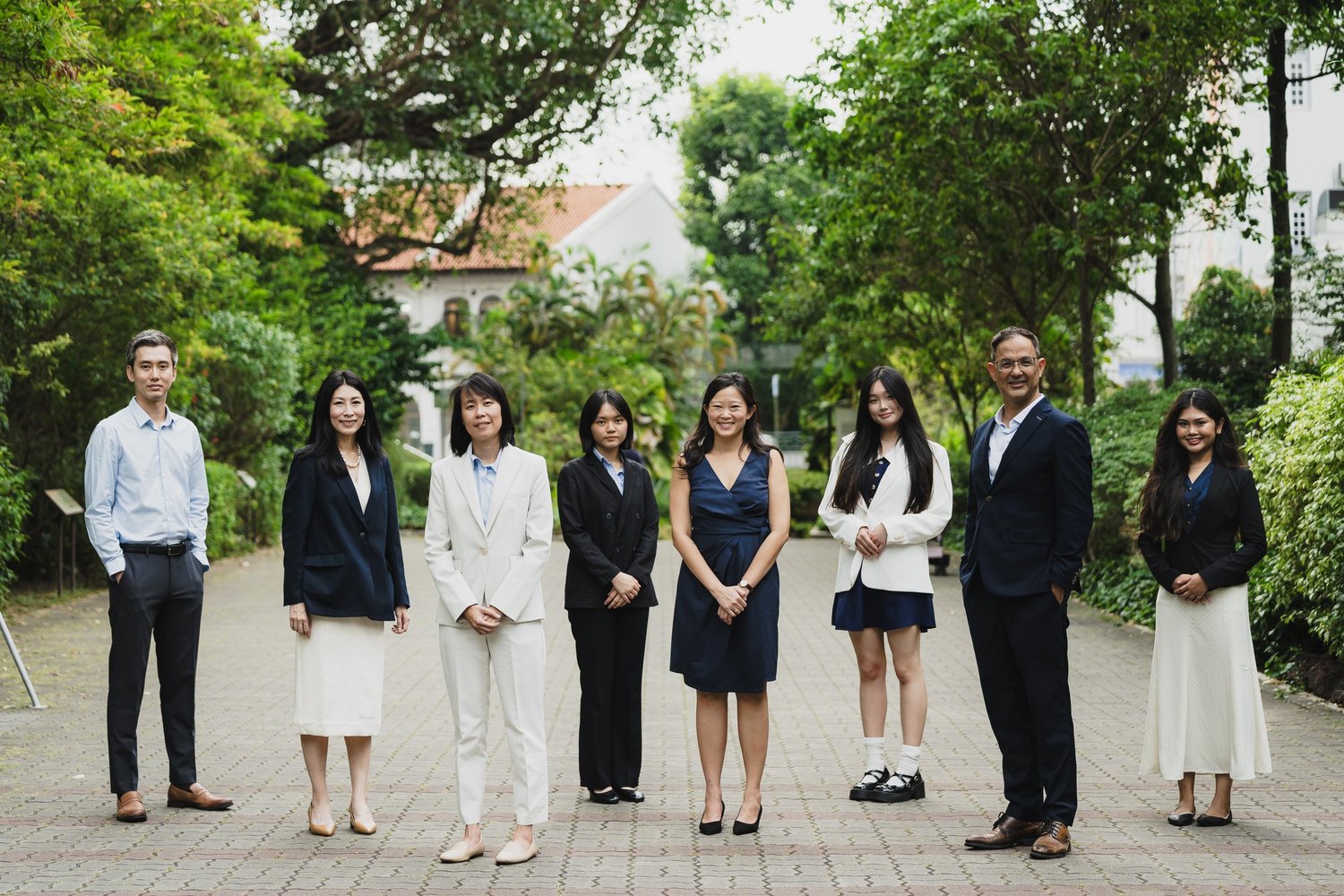 The Linea Law team standing together outdoors, with trees and white buildings behind them